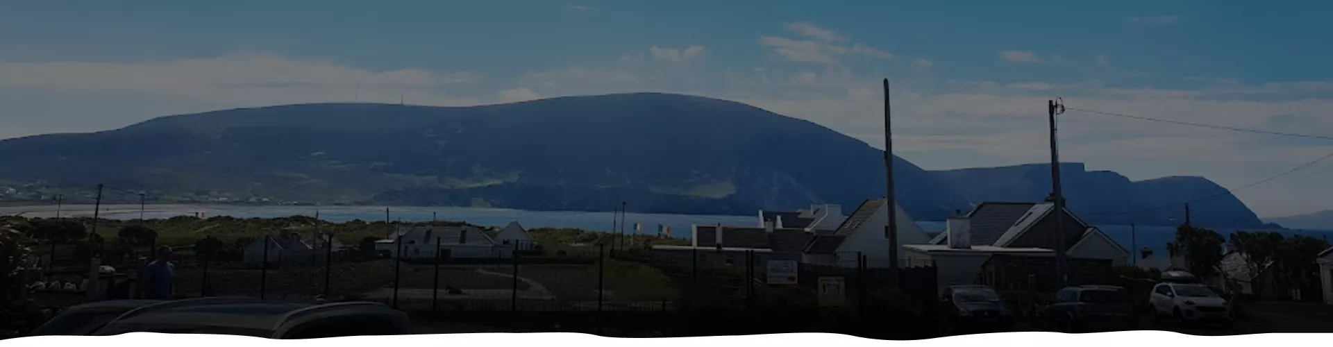 Silhouetted landscape with mountain backdrop and industrial foreground.
