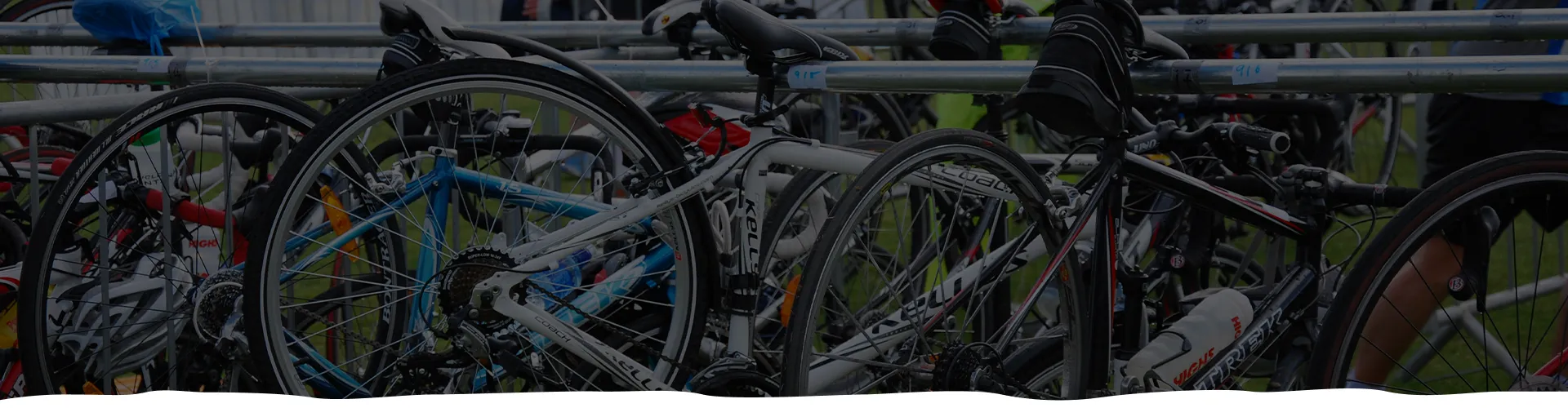 Bicycles stacked closely on a metal rack outdoors.